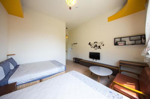 a room with two beds and a table and a tv at Fire Island Guest House in Green Island