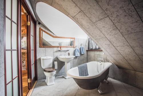 een badkamer met een bad, een toilet en een wastafel bij Karja Castle Apartments in Haapsalu