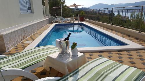 a swimming pool with a table and chairs next to it at Luxury Villa Star Lights Trogir - heated pool, hot tub, gym, billiard in Trogir
