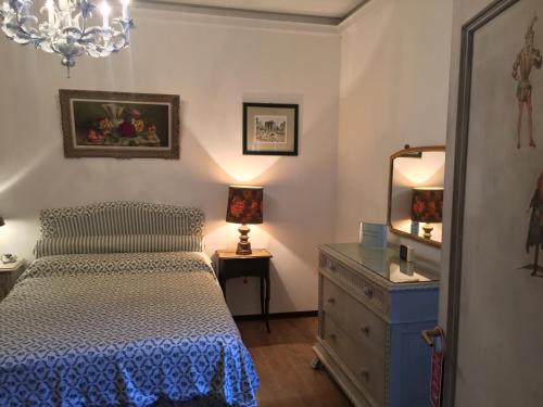 Schlafzimmer mit einem Bett, einer Kommode und einem Spiegel in der Unterkunft Il Vecchio Teatro in Biella