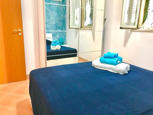 シクリアーナ・マリーナにあるLe Terrazze - "dalla Nonna"の青と白のタオルが備わるベッド1台が備わる客室です。