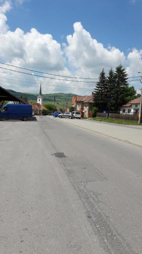 an empty street with a church in the distance at Lörincz Vendégház in Corund