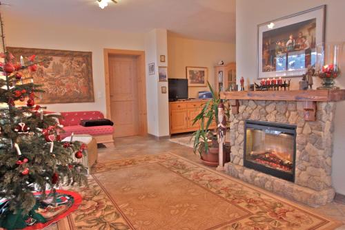 a living room with a christmas tree and a fireplace at Bergkristall in Stummerberg