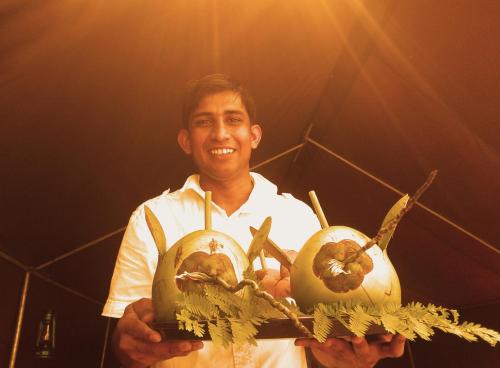 a man is holding two vegetables in his hands at Big Game - Wilpattu by Eco Team in Wilpattu