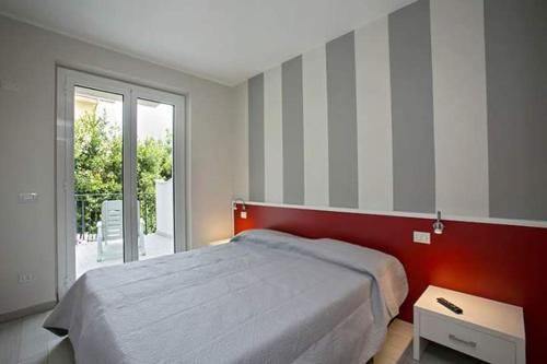 - une chambre avec un grand lit et une tête de lit rouge dans l'établissement Casa Orti, à Grottammare
