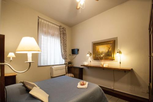 a bedroom with a blue bed and a window at La Colonna (Historic Centre) in Lucca