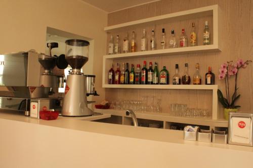 - une cuisine avec un bar avec des bouteilles et des verres dans l'établissement Hotel Clara, à Riccione