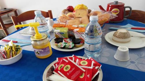 a blue table topped with plates of food and bottles of water at B&B Pani Silvio in Perfugas