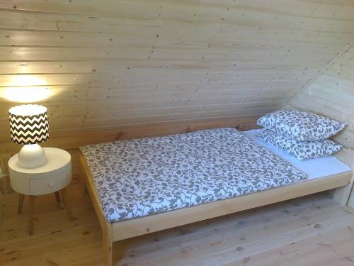 Un pat sau paturi într-o cameră la Nowe Domki Pod Lipami