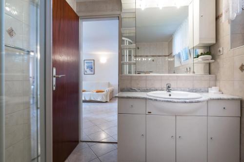 a bathroom with a sink and a mirror at Beach apartment M & B in Poljana