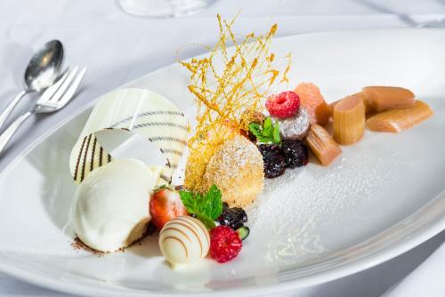 a white plate with desserts on a table at Parkhotel Graz - Traditional Luxury in Graz