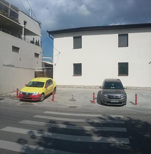 two cars parked in a parking lot next to a building at Apartament Fundeni Sofia in Bucharest
