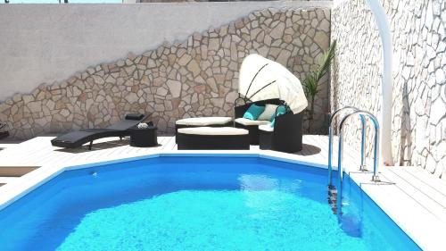 una piscina di fronte a un muro di pietra di Il Giardino delle Jacaranda a Talsano