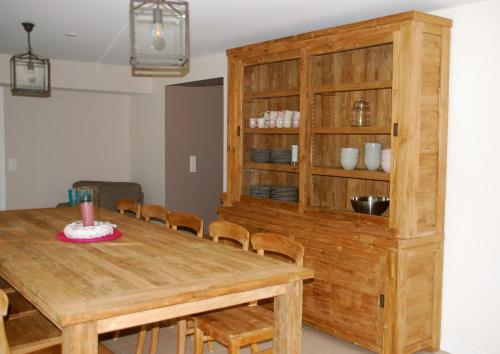 een eetkamer met een houten tafel en stoelen bij Les Haies in Solwaster