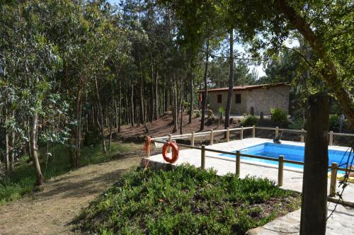 a swimming pool in a yard next to a house at Quinta dos Mangues in São Martinho do Porto