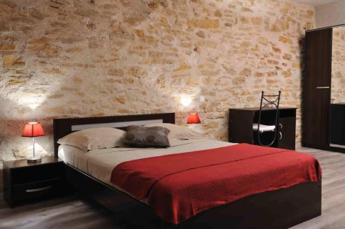 a bedroom with a bed with a brick wall at Les Chambres d'Eponine in Saints-Geosmes