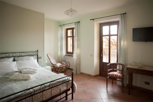 a bedroom with a bed and a desk and chairs at Il Germano Reale in Alba