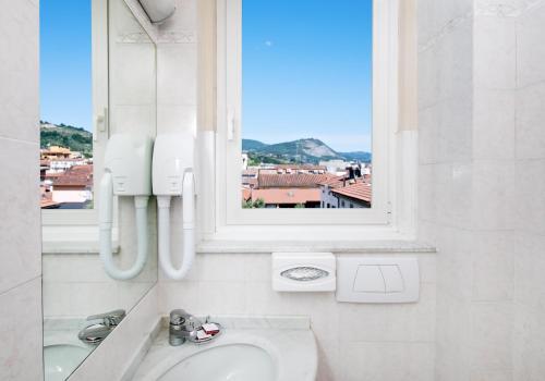 a bathroom with a sink and a window at Hotel Ercolini & Savi in Montecatini Terme