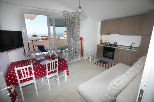 a kitchen and living room with a table and a couch at Appartamenti DeSi in Tropea