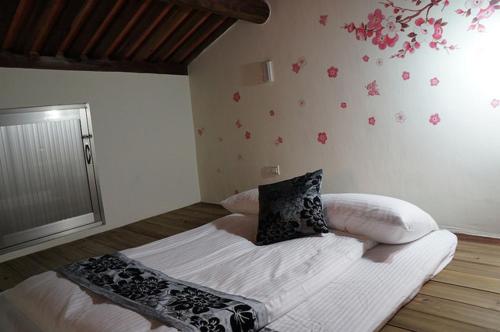 a bedroom with a bed with flowers on the wall at Teapot House in Jinning