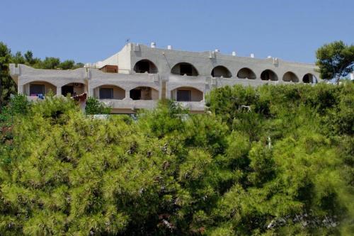 a building on top of a hill with trees at Hotel Abatis in Skala