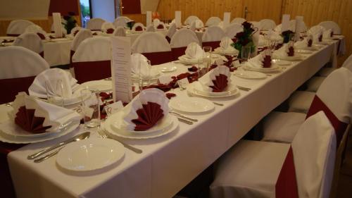 a long table with white plates and napkins on it at Hotel Restaurant Stöckl in Bad Deutsch Altenburg