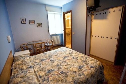 um quarto com uma cama, uma mesa e uma janela em Albergo della Posta em Clusone