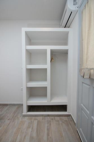 a walk in closet with white shelves and a door at Relax Studios in Naxos Chora
