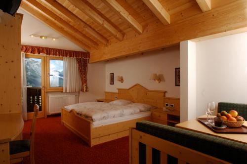 a bedroom with a bed and a table in a room at Hotel Falzares in San Cassiano