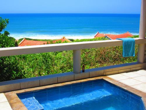 a swimming pool on a balcony with a view of the ocean at Go Wild Beach Resort in Xai-Xai