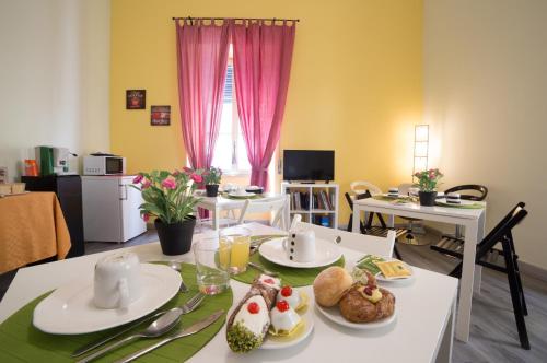 ein Esszimmer mit einem Tisch mit Essen drauf in der Unterkunft Tra L'Etna E Il Mare B&B in Catania