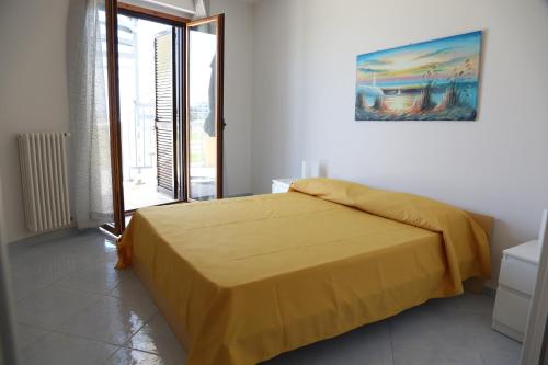 マルゲリータ・ディ・サヴォイアにあるEden Villageのベッドルーム1室(黄色い毛布付きのベッド1台付)