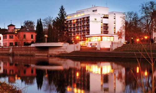 a building next to a body of water at night at Caravelle Hotel im Park in Bad Kreuznach