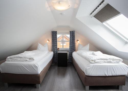 two beds in a attic room with white sheets at Apartment Am Gerkenstein 29-M, Winterberg-Neuastenberg in Winterberg