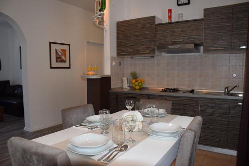 een keuken met een tafel met borden en wijnglazen bij Apartments Zelic in Vodice