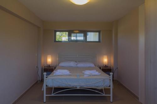 1 dormitorio con 1 cama con 2 mesitas de noche y 2 lámparas en Perivoli House B, en Skala Eresou