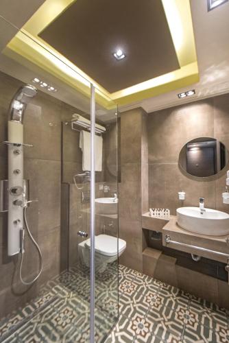 a bathroom with a shower and a toilet and a sink at Armonia Lux Studios in Ierissos