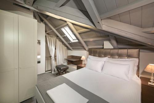 a bedroom with a large white bed and a desk at Armonia Lux Studios in Ierissos