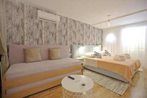 a small bedroom with two beds and a table at Central Apartments Integrated Hotel in Zadar