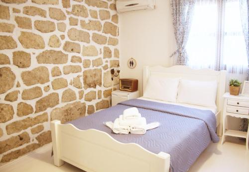 a bedroom with a stone wall and a bed at Morlimon in Alaçatı