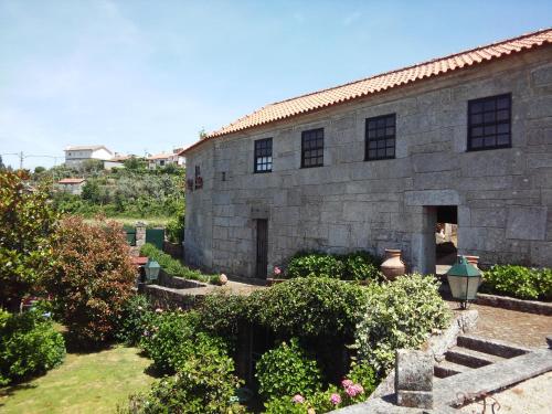 un edificio de piedra con un jardín delante de él en Casa Aido Santo en Pinheiro de Lafões