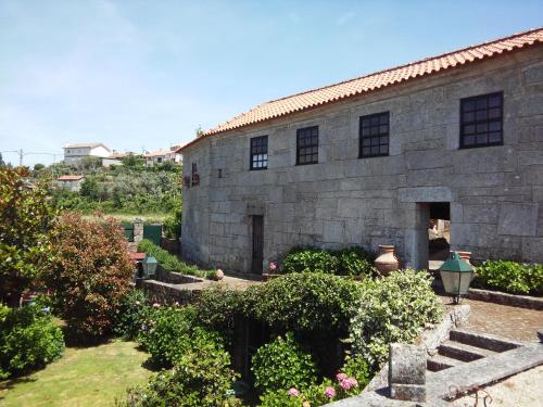 a stone building with a garden in front of it at Casa Aido Santo in Pinheiro de Lafões