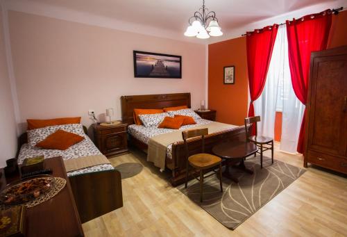 a bedroom with two beds and a table and chairs at Phiros B&B in Piran
