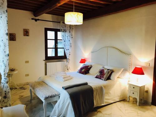 Un dormitorio con una gran cama blanca y una ventana en La Casa Duchessa, en Chianni