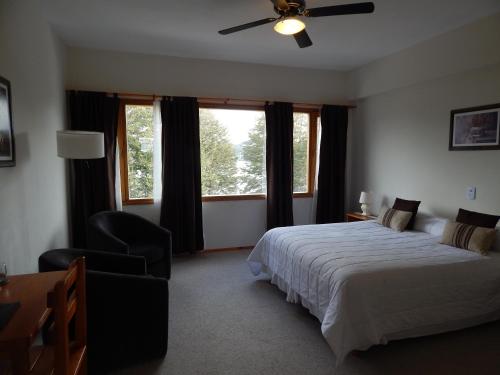 a bedroom with a bed and a ceiling fan at Peninsula de los Coihues in Villa Pehuenia