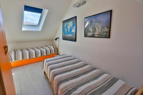 a bedroom with a bed and two pictures on the wall at Vacation home Vibor in Dračevica