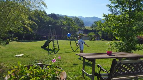 a young child playing with a blue balloon in a yard at Mas Manyaques in Le Tech