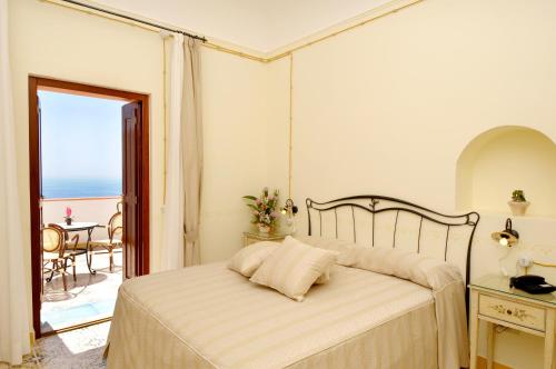 a bedroom with a bed with a view of the ocean at Locanda Degli Dei in Praiano
