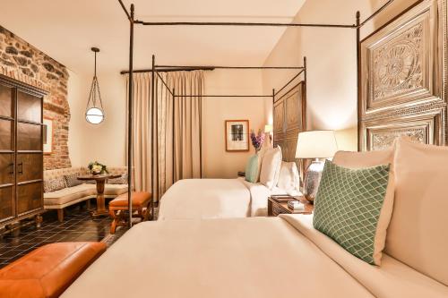 a hotel room with two beds and a couch at Banyan Tree Puebla in Puebla