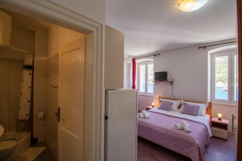 a small bedroom with a bed and a bathroom at Apartment Riva 5 in Komiža